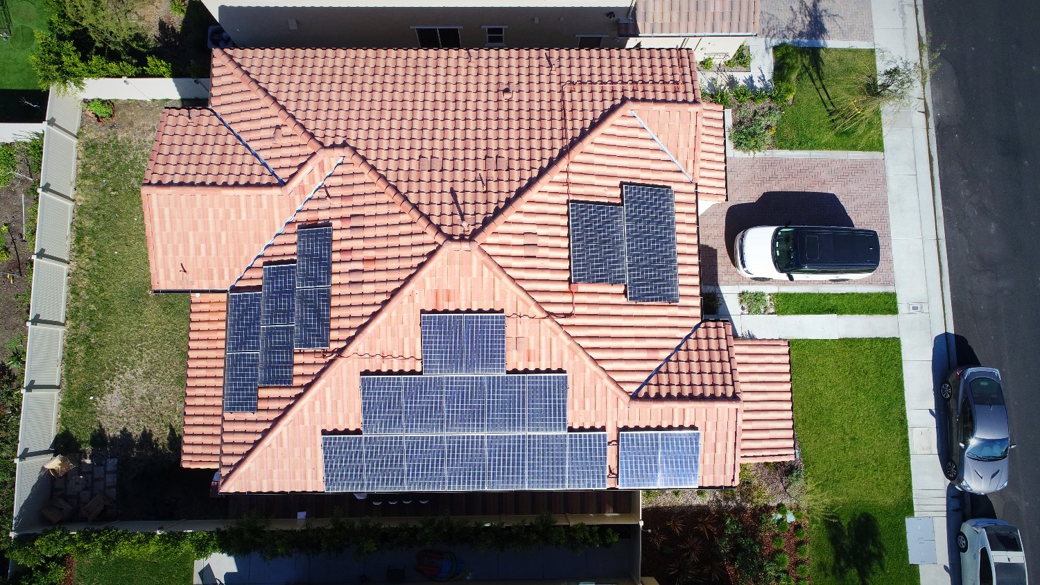 A birds eye view of a residential roof with solar panels.